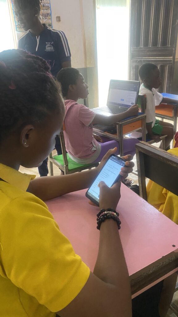 A female student with a phone in her hand having tech examination in a class room - EpeeTech Solution (Cardon Standard Schools)