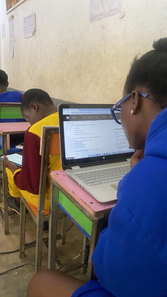 A female student with a laptop in her front having tech examination in a class room - EpeeTech Solution (Cardon Standard Schools)